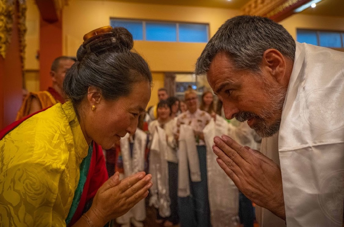 Antoni Fernández y Khadro-la se saludan con las manos juntas; Antoni lleva una khata blanca sobre los hombros